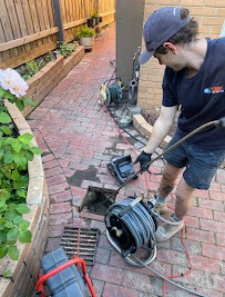 Professional plumber working with drain inspection equipment